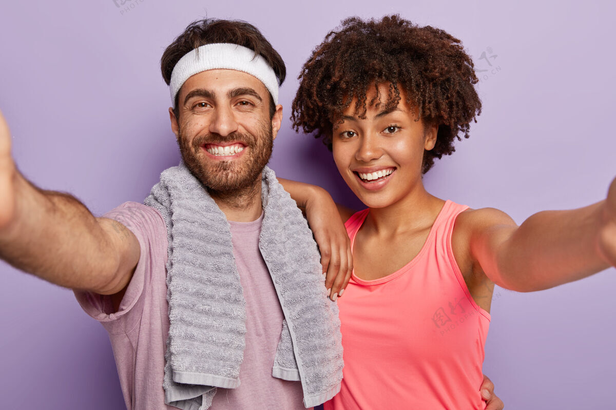 跑步快乐混血男女写真自拍写真 积极微笑 身着运动服 积极锻炼 隔着紫色的画室墙与世隔绝女人情侣摄影师