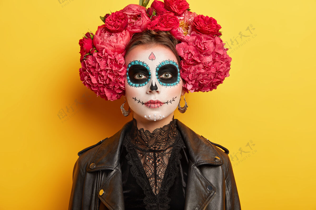 装束年轻的女人有时髦的妆容和服装 戴着红色的花环 对墨西哥两天的假期有着传统的看法 沐浴在黄色的阳光下严肃花环红色