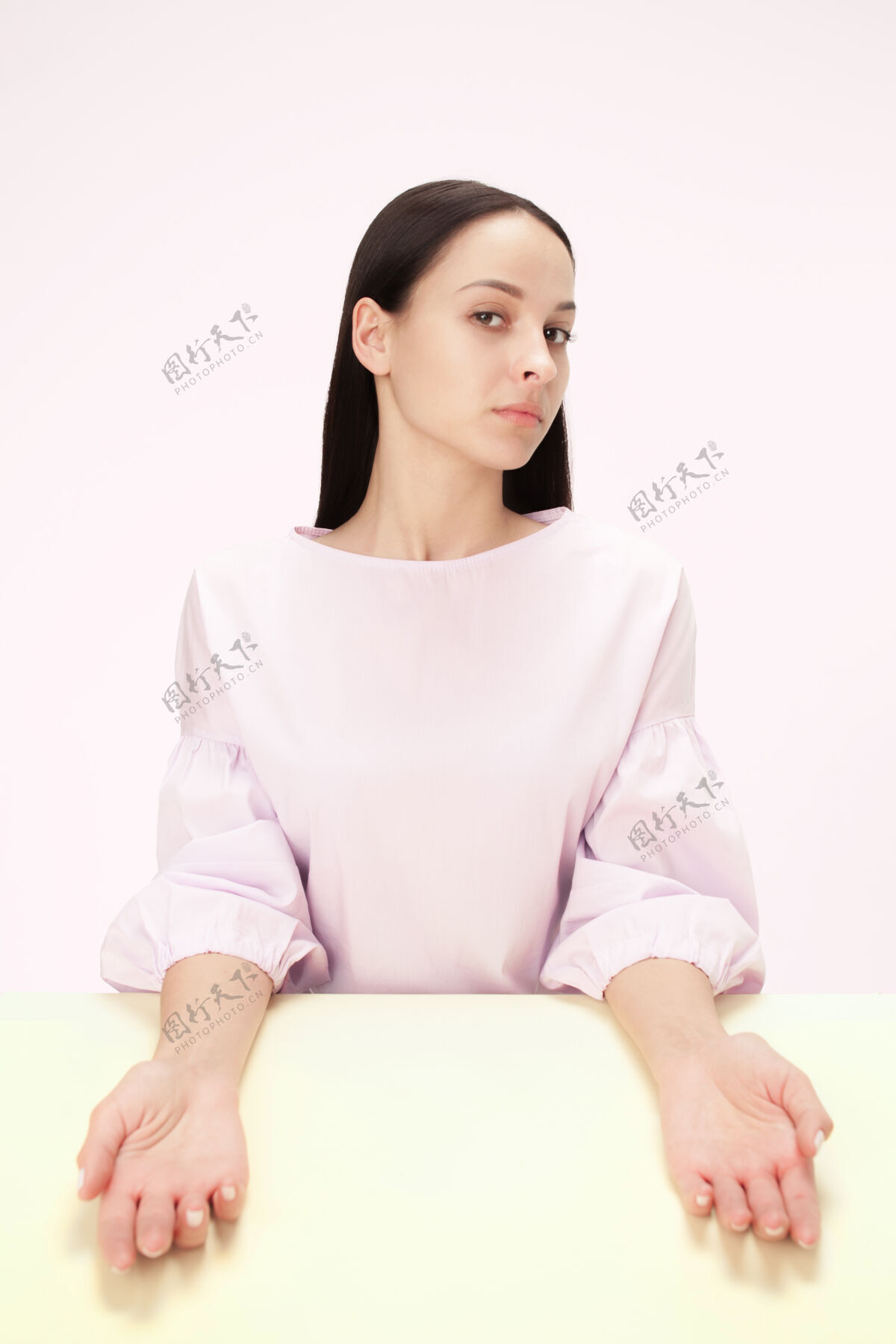 自信正经的女商人坐在粉红色的桌子旁现在表情悲伤
