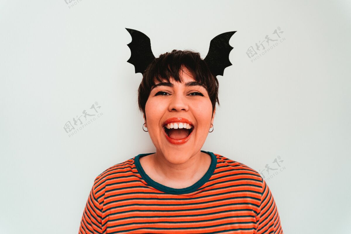 女性自画像一个微笑的白人女性与蝙蝠形头带恐怖头骨翅膀