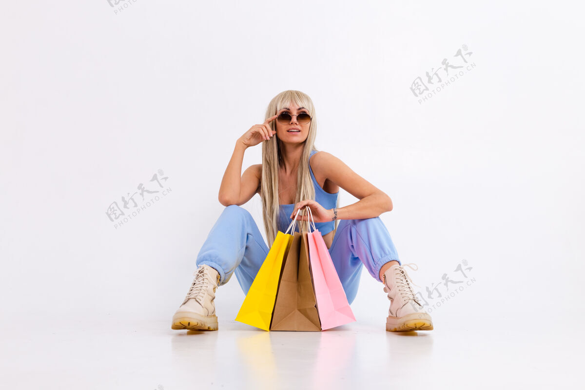 女性年轻金发女郎的时尚写真 长着华丽的直发 带着五颜六色的购物袋 在摄影棚里一头白色的头发上折扣可爱购买