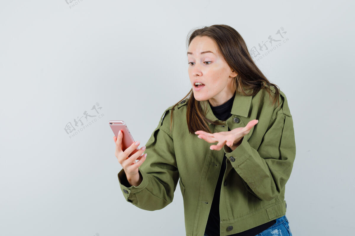 时尚穿着绿色夹克的年轻女子在视频通话中与人争吵 正面视图女人期间视频