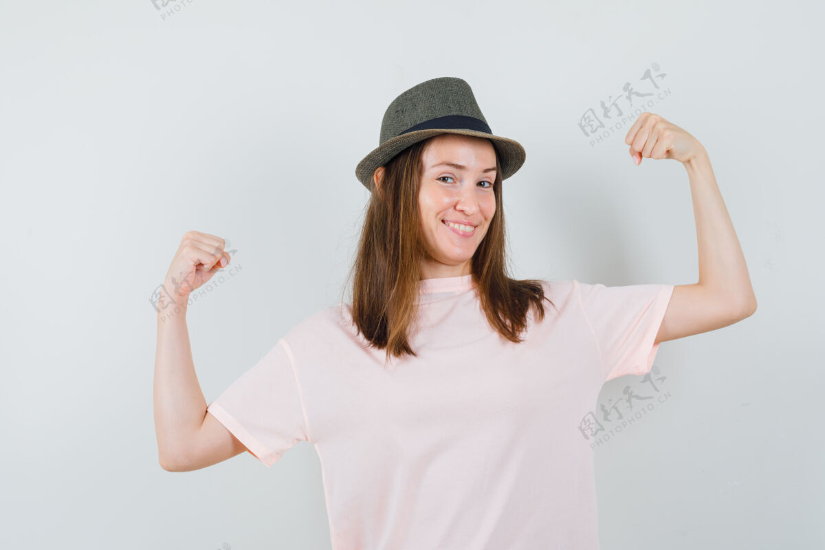 帽子穿着粉色t恤 戴着帽子 看上去很高兴的年轻女孩展示了赢家的姿态正面图微笑快乐肖像