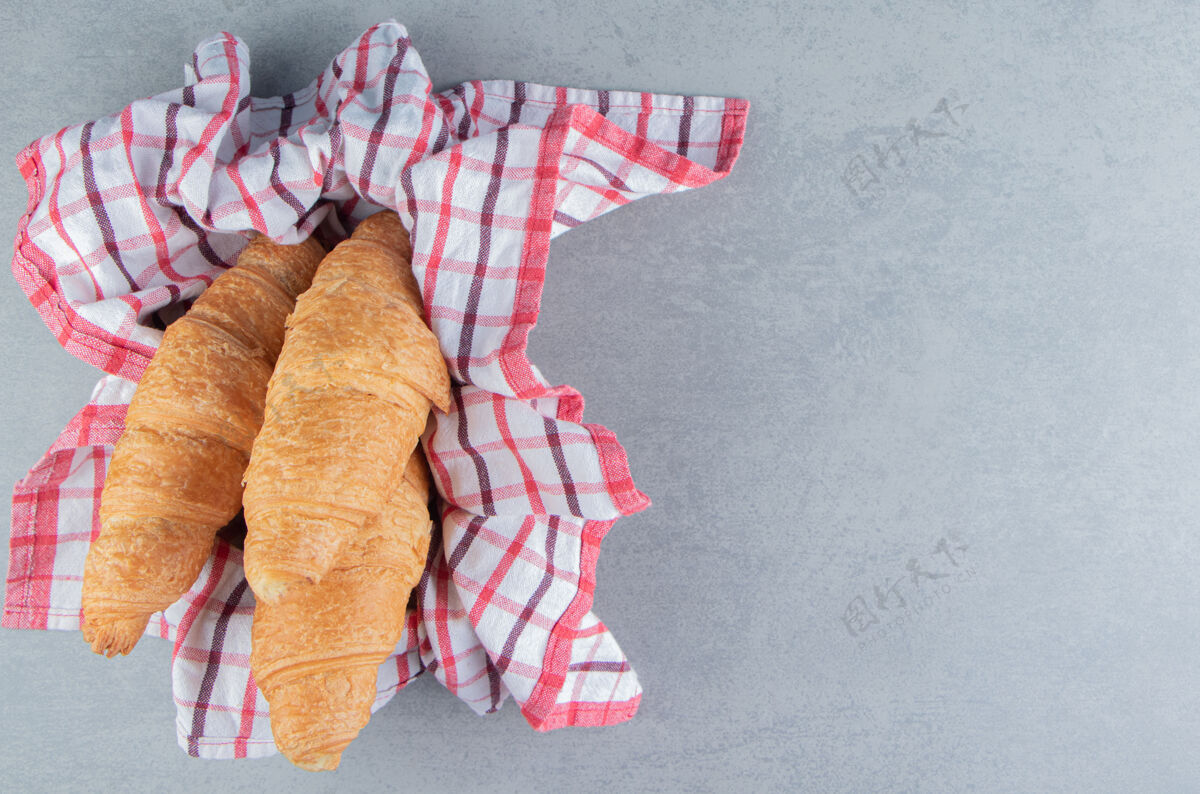 配料牛角面包放在碗里的毛巾上 大理石背景上高质量的照片甜味烘焙牛角包