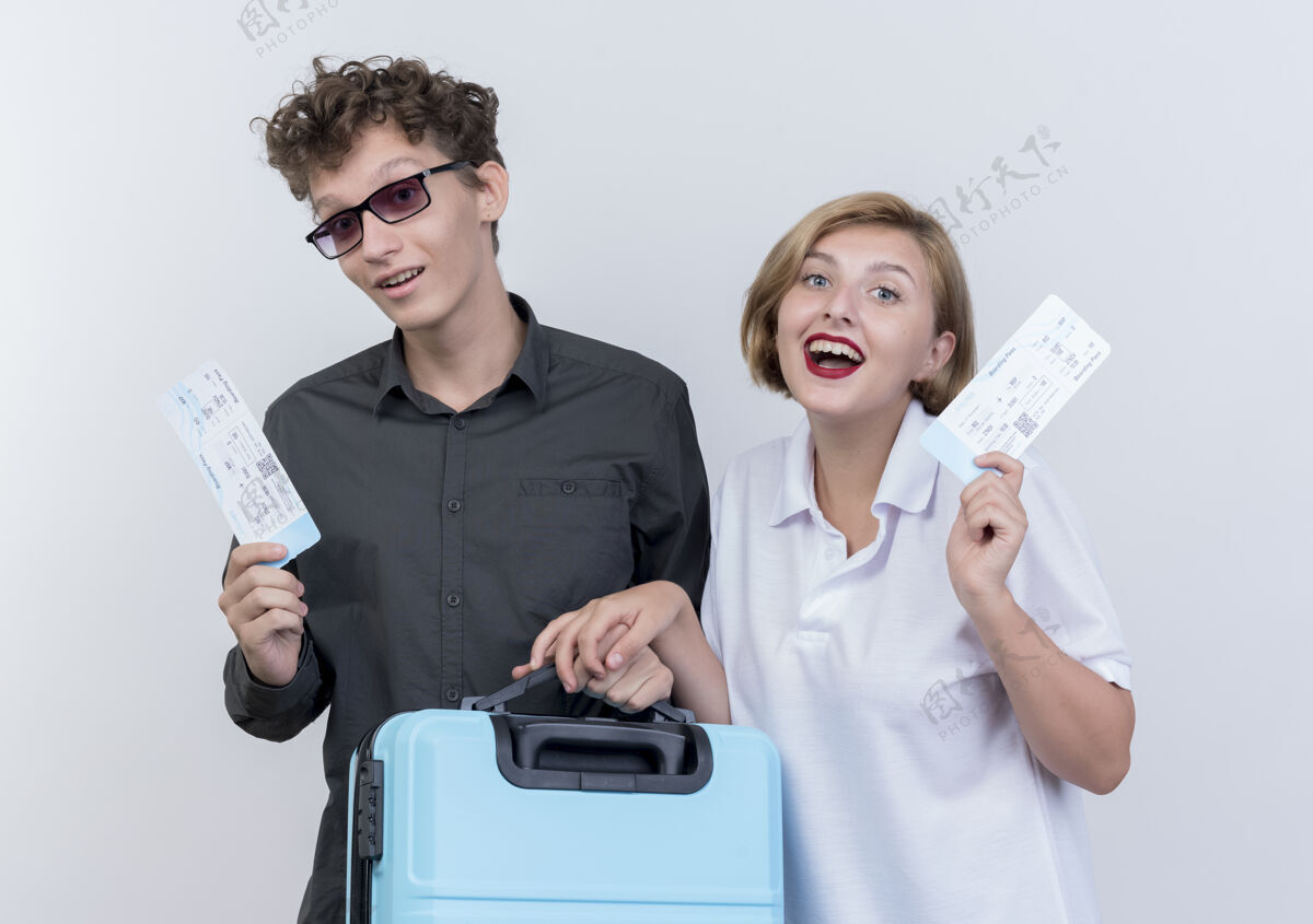 男人一对幸福的年轻游客 一男一女拿着机票和手提箱站在白墙上票手提箱年轻人