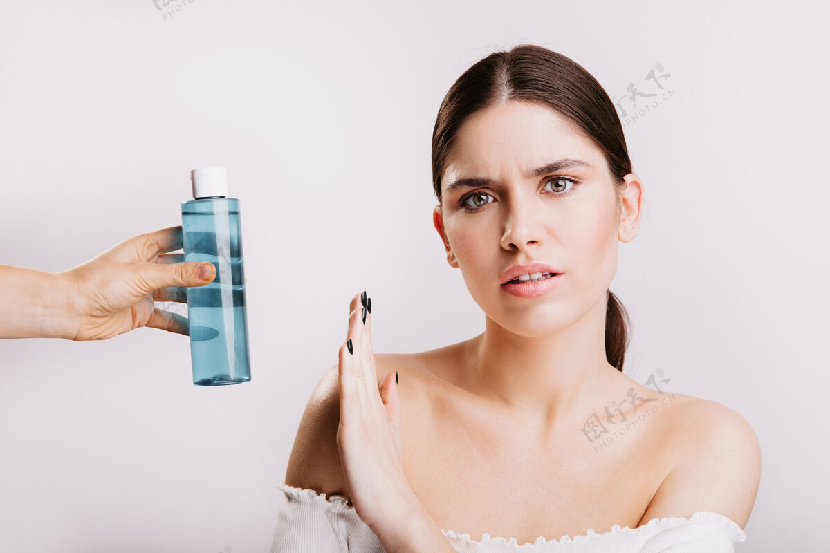 护理用胶束水在白墙上画出一幅女孩不高兴的表情不化妆的女人禁止使用化妆品不化妆自然清新