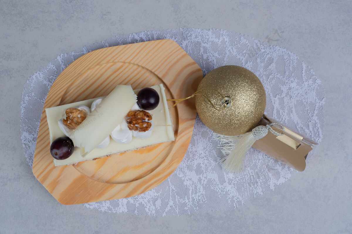 巧克力木制盘子上的白巧克力蛋糕 有圣诞礼物和舞会高品质照片球谷物盒子