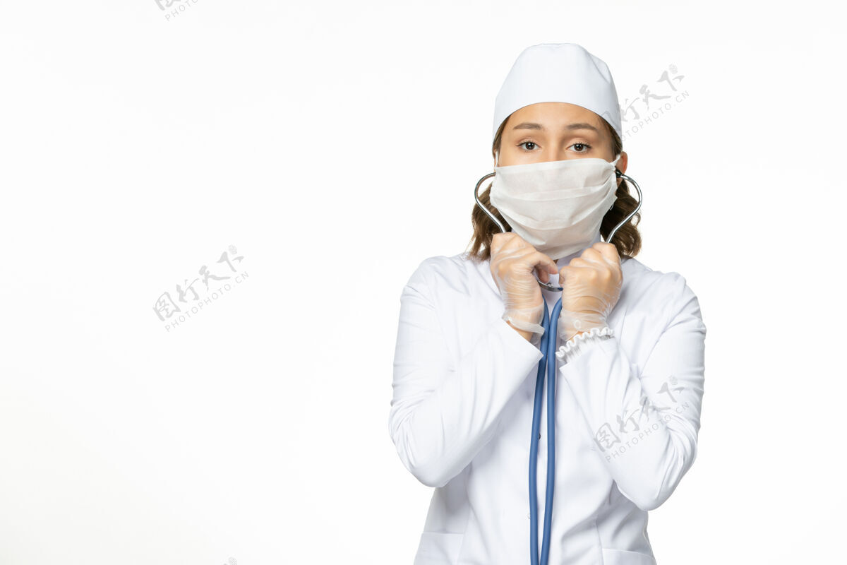 面罩白色办公桌上戴着无菌口罩的年轻女医生冠状病毒病毒耳机