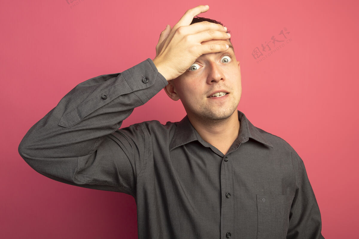男人一个穿着灰色衬衫的年轻帅哥 用手捂着额头 看上去既焦虑又困惑粉色衬衫担心