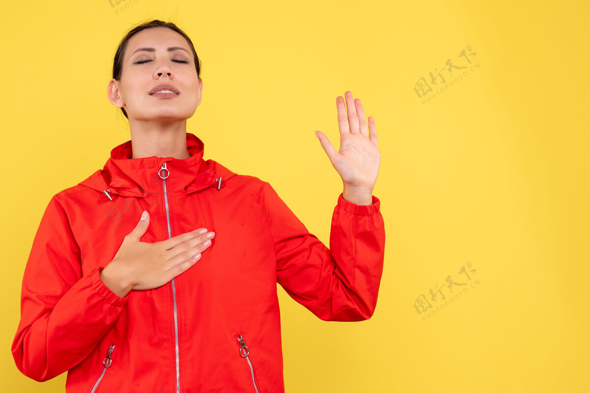 女人黄色书桌上穿着红色外套的年轻女性的正面图红情绪运动员