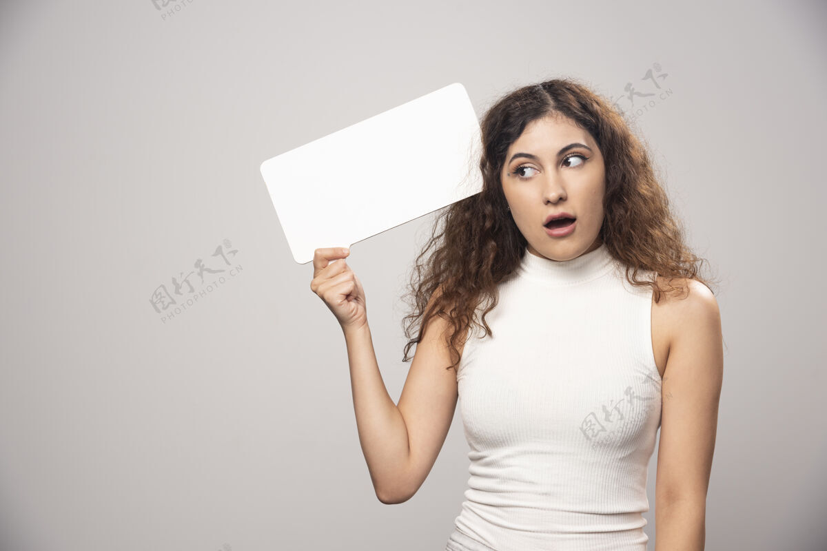 漂亮年轻女子举着空白的白色演讲海报高质量的照片头发人女士