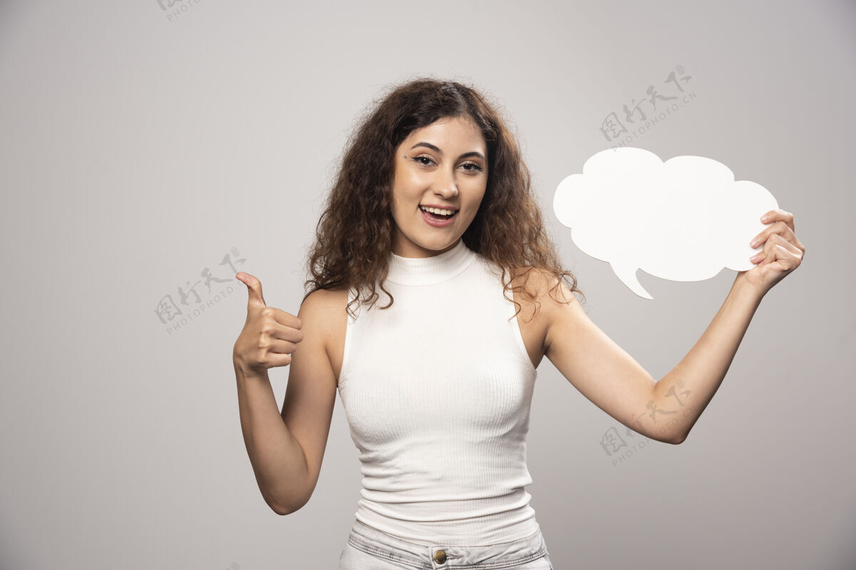 头发年轻女子举着大拇指 举着白色的空白海报高质量的照片成人人人
