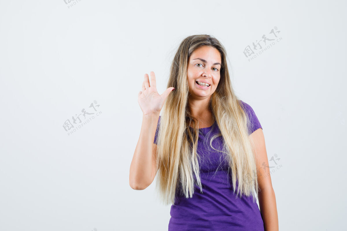 肖像身着紫罗兰色t恤的年轻女士挥手致意 愉快地看着前方景色人兴奋紫罗兰