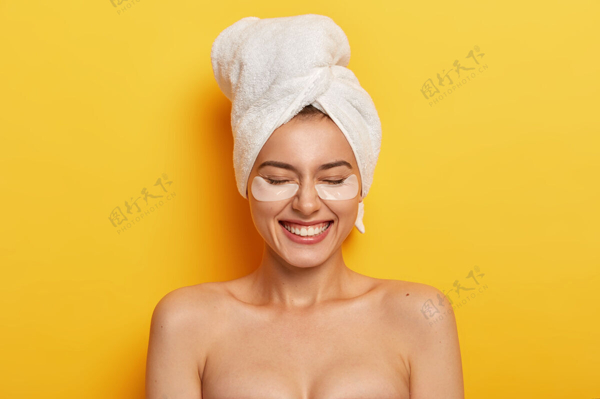 面部满意美女裸女头巾在眼睛下敷白斑以减少干燥 有娇惯疗程 丰满肌肤 淋浴后头上戴白毛巾室内日常裸体
