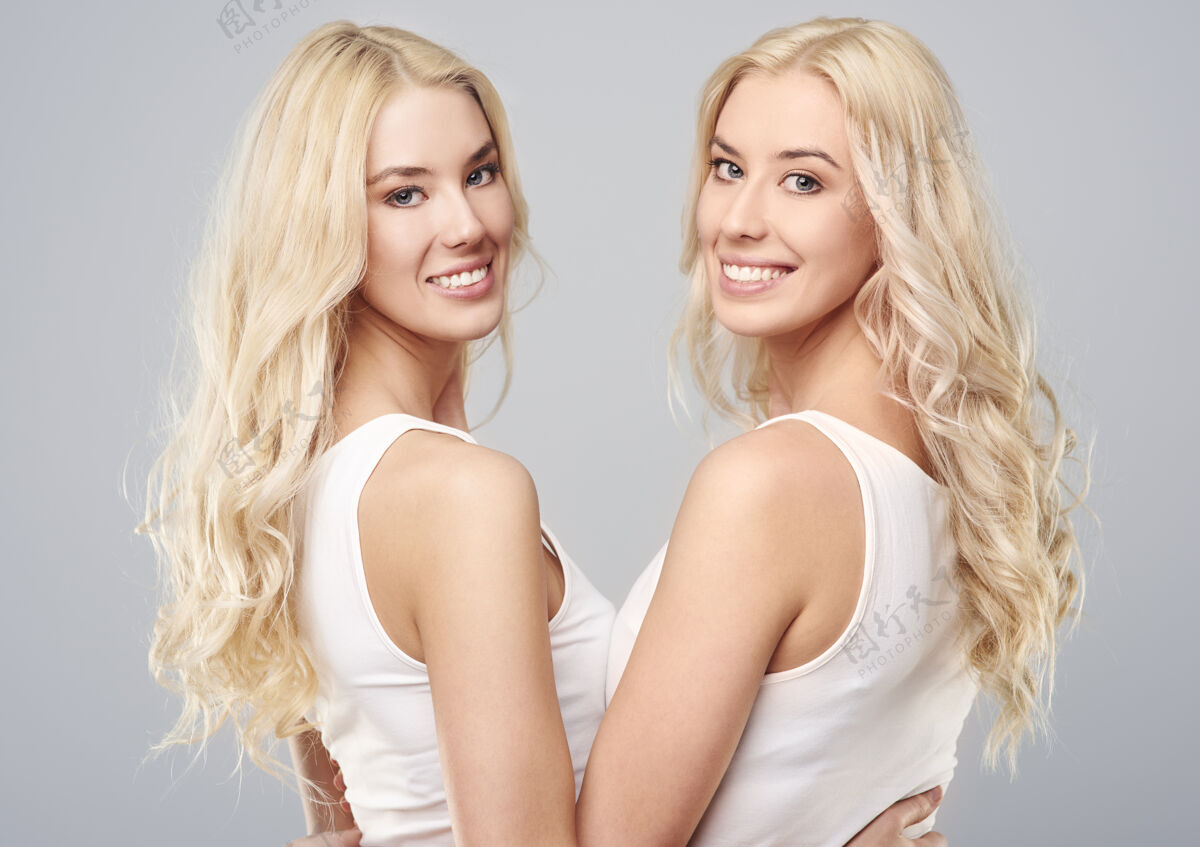 双人金发女孩双胞胎的后视图双胞胎成人转身
