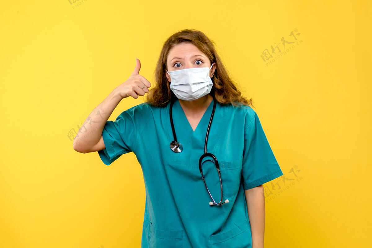 人黄色空间里戴着面具的女医生的正视图护士实验外套服装