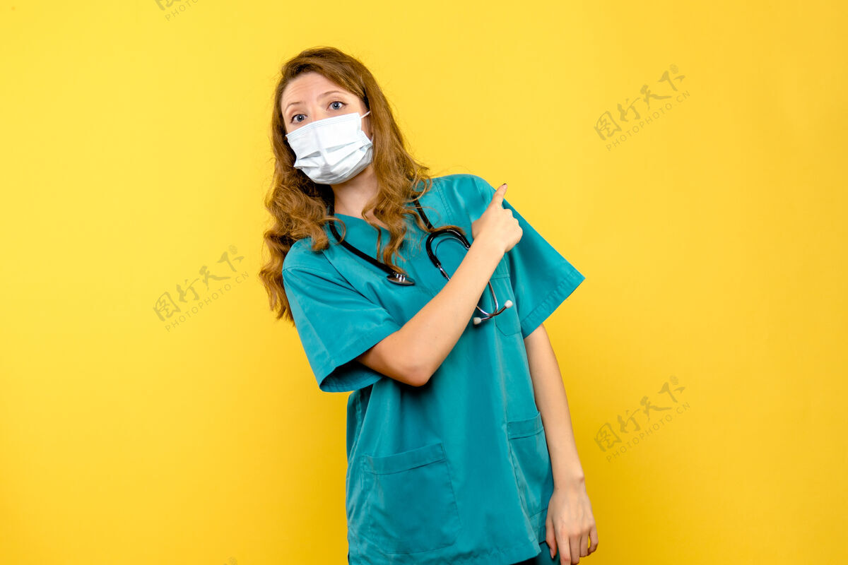 黄色黄色空间里戴着面具的女医生的正视图人女医生微笑