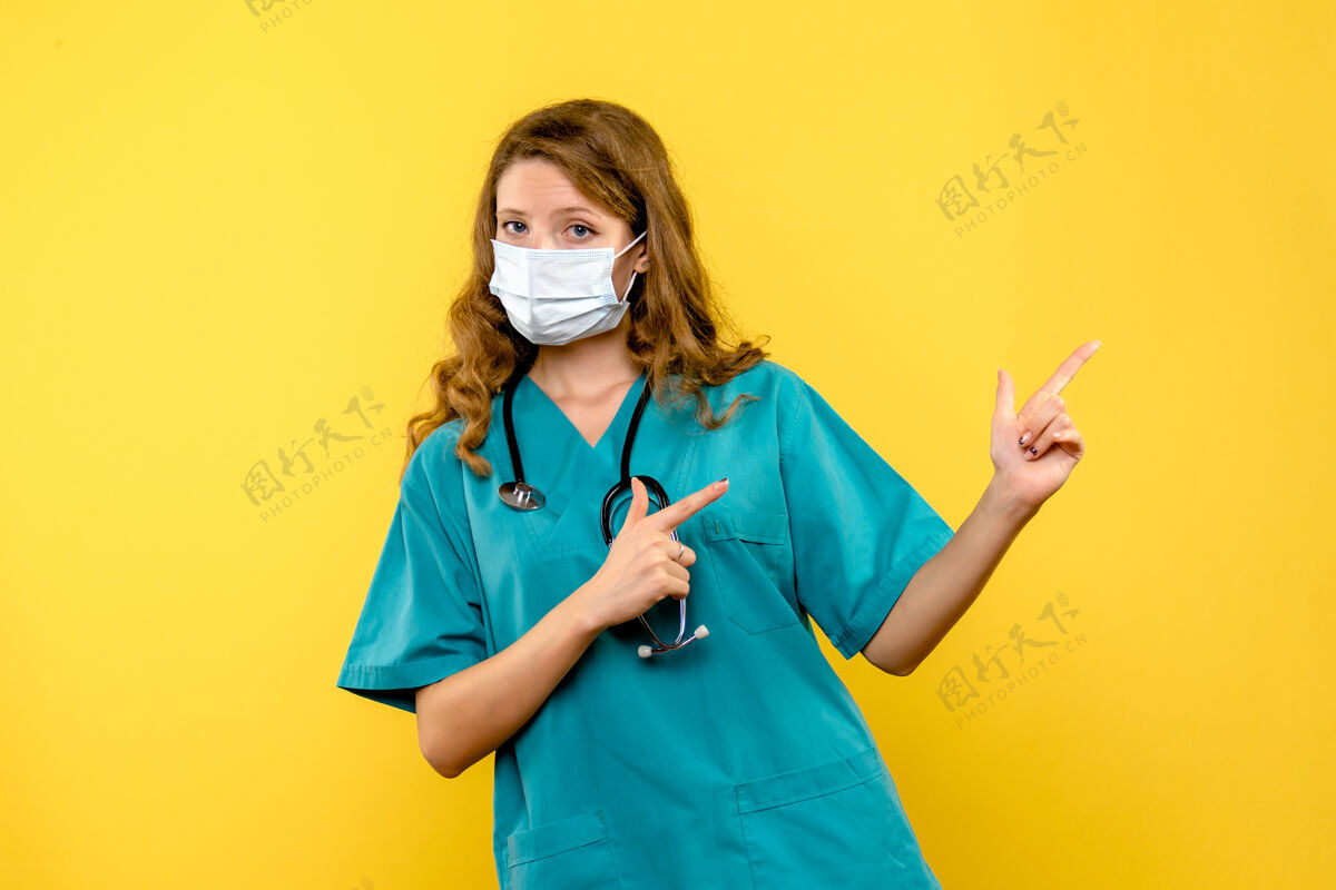 视图黄色空间里戴着面具的女医生的正视图面罩仪器医院