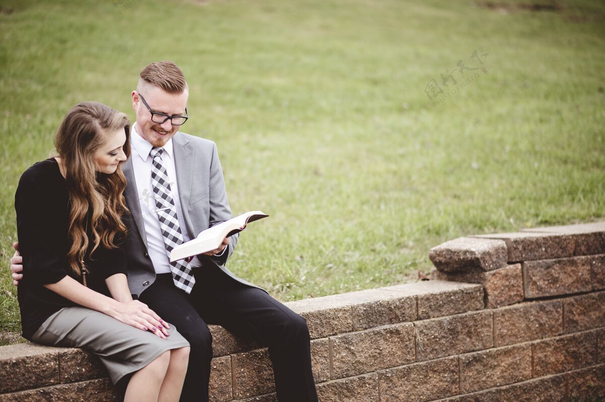 约会一对夫妇坐在花园里 一起深情地读着一本书衣服正式宗教