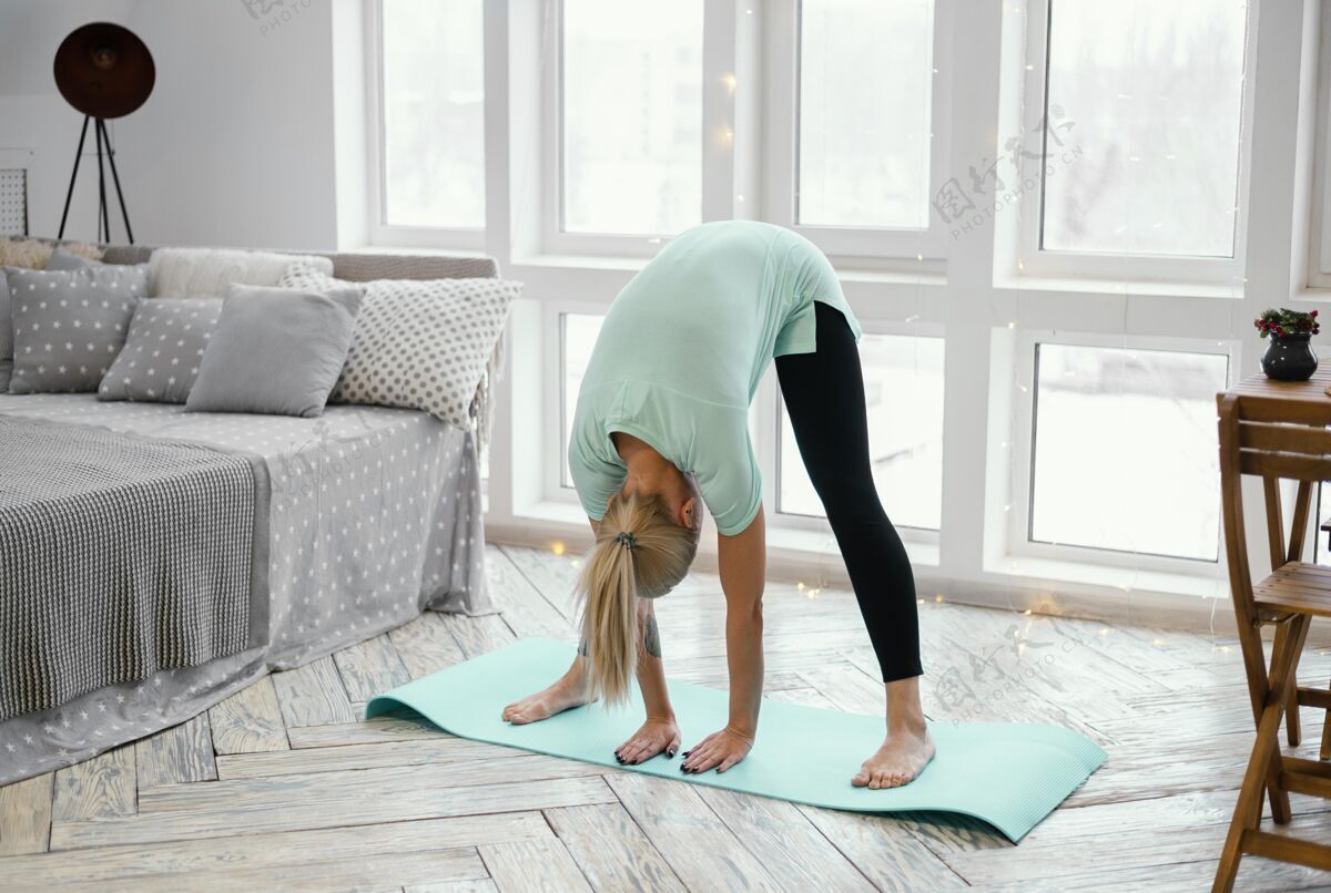 房子女运动员在垫子上锻炼锻炼瑜伽垫伸展