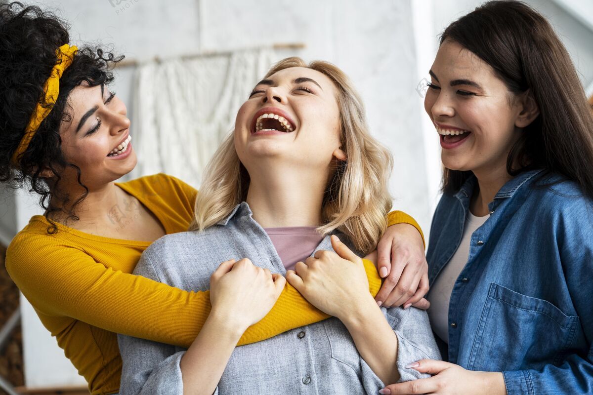 庆祝三个拥抱的女人一起笑快乐女性乐观