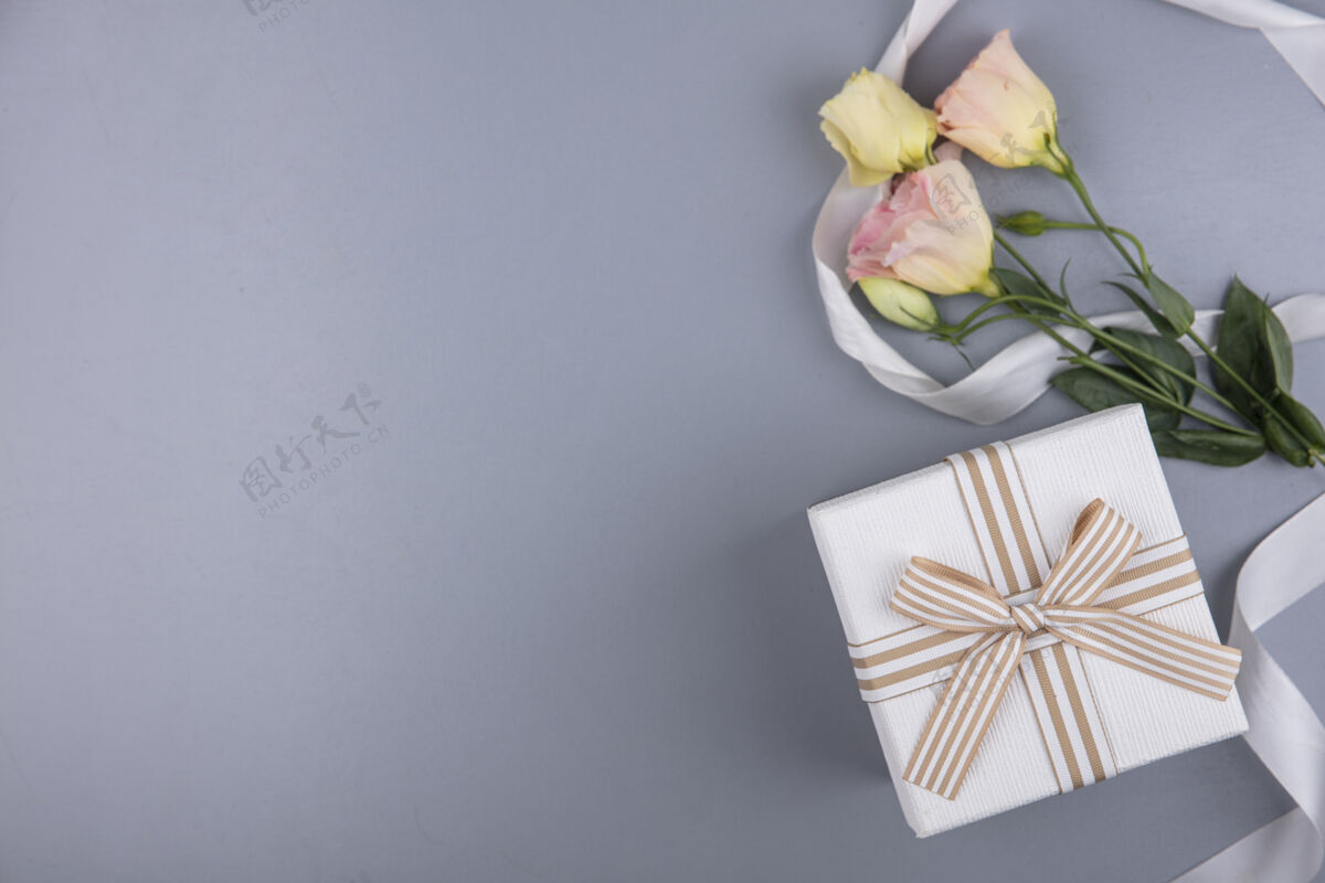 礼物顶视图的礼品盒和花卉与丝带灰色背景与复制空间圣诞灰色空间