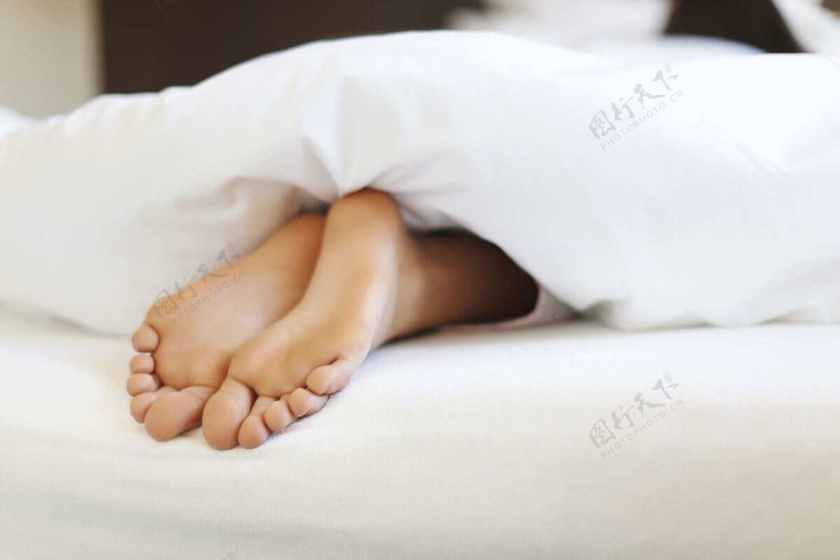 腹部床上女性脚的特写镜头梦舒适不可辨认的人