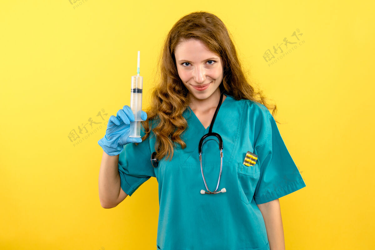 视图正面图黄色空间女医生拿着大针头医疗器械冠状病毒持有