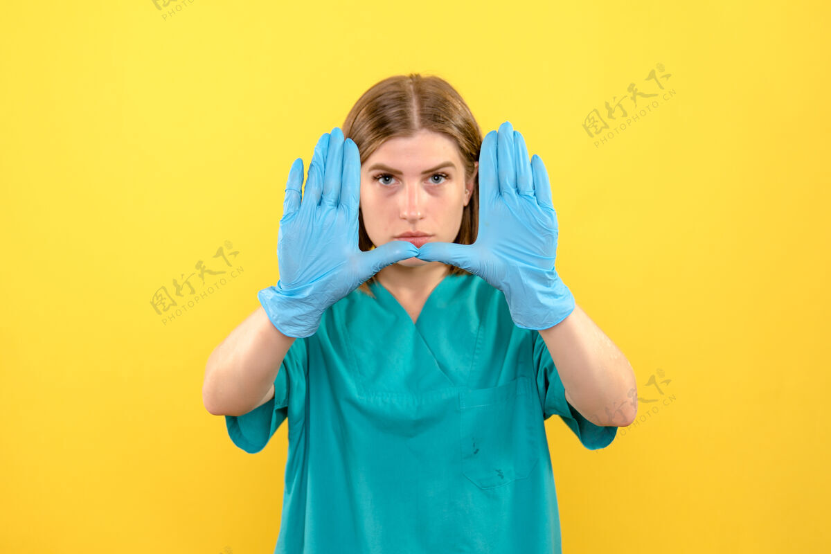 成人前视图女医生在黄色空间展示蓝色手套球员男孩男人