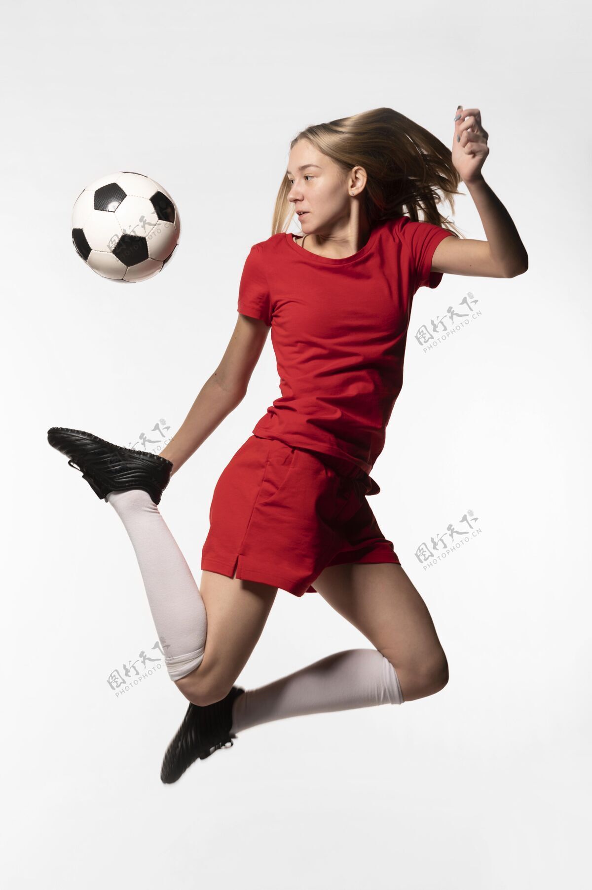 足球运动员女足球运动员踢球跳跃足球制服踢