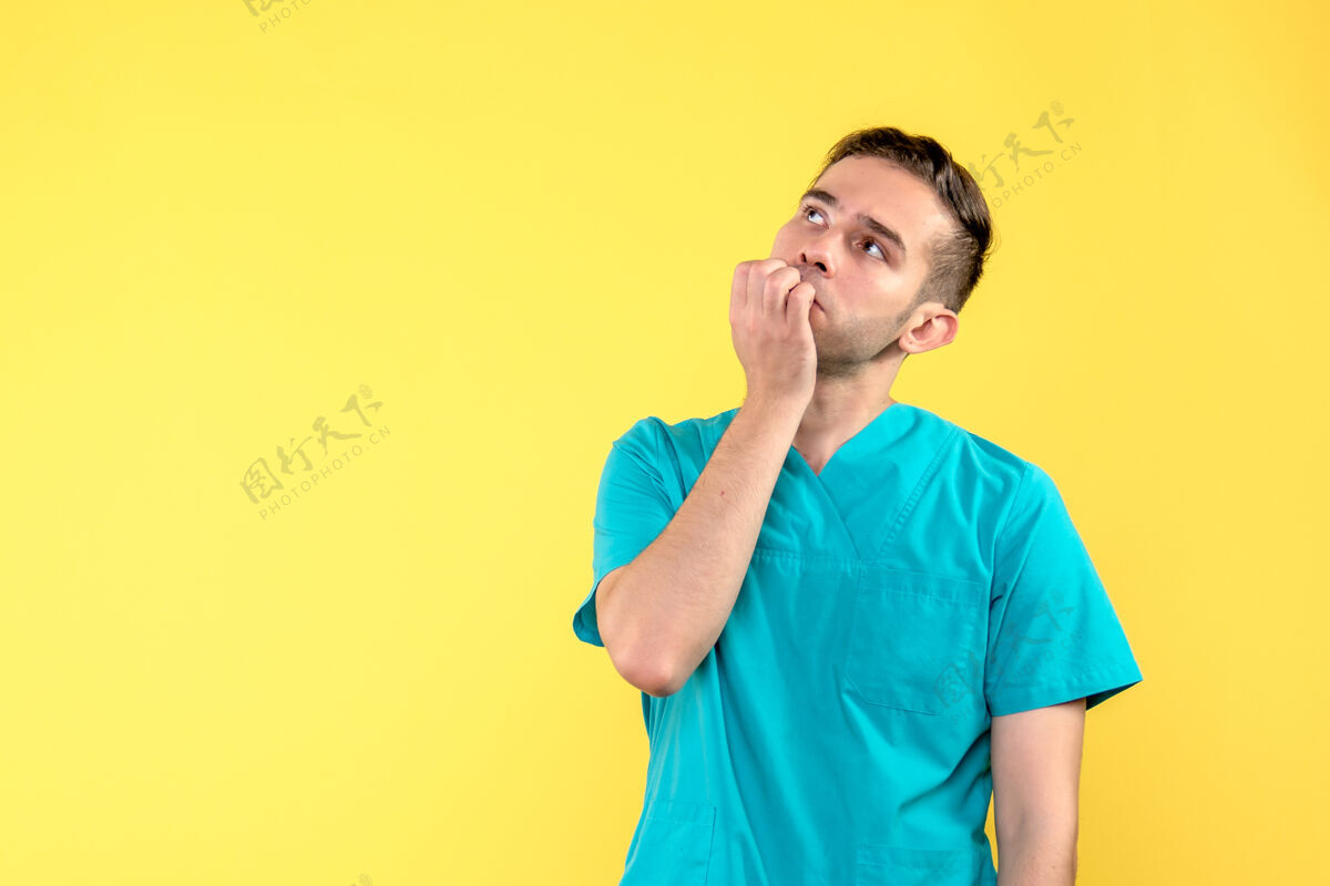 医学黄墙上男医生沉思的正面图前面医院人