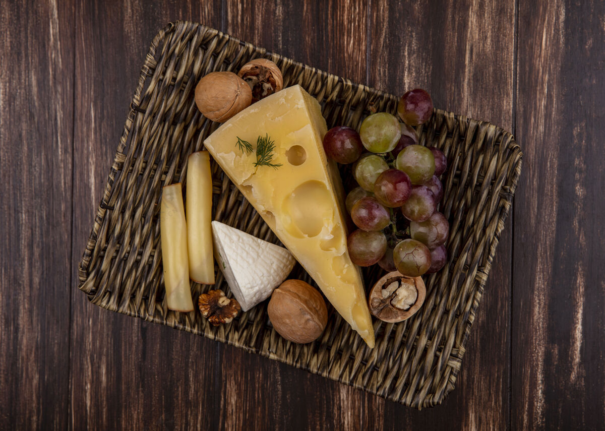 坚果顶视图葡萄与奶酪和坚果品种的立场上反对一个木制的背景奶酪木材景观