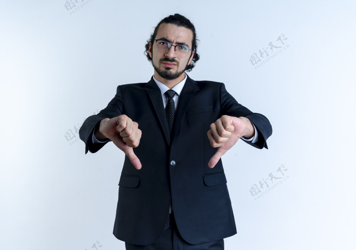 公民一个穿着黑西装戴着眼镜的商人不高兴地站在白墙上竖起大拇指朝前看生意看站