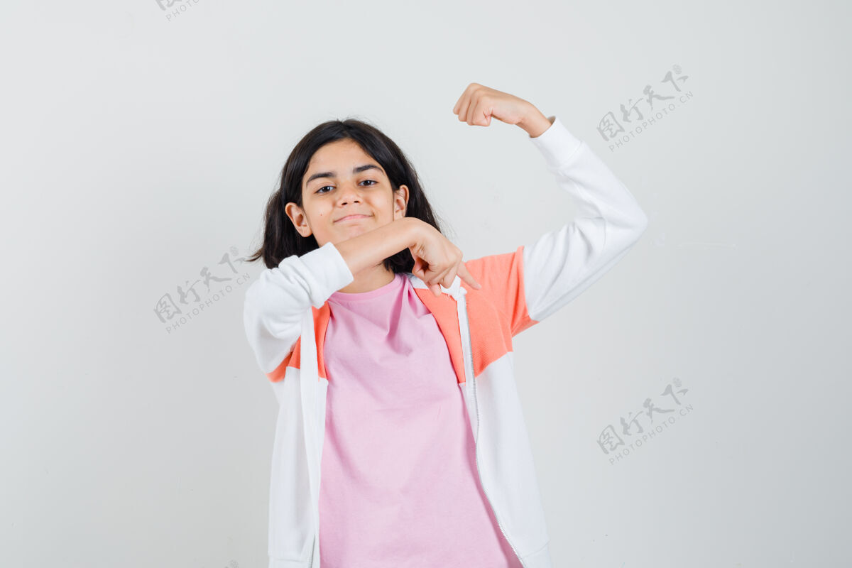 表演一个穿着夹克衫 粉色衬衫 炫耀手臂肌肉的少女时尚情感年轻