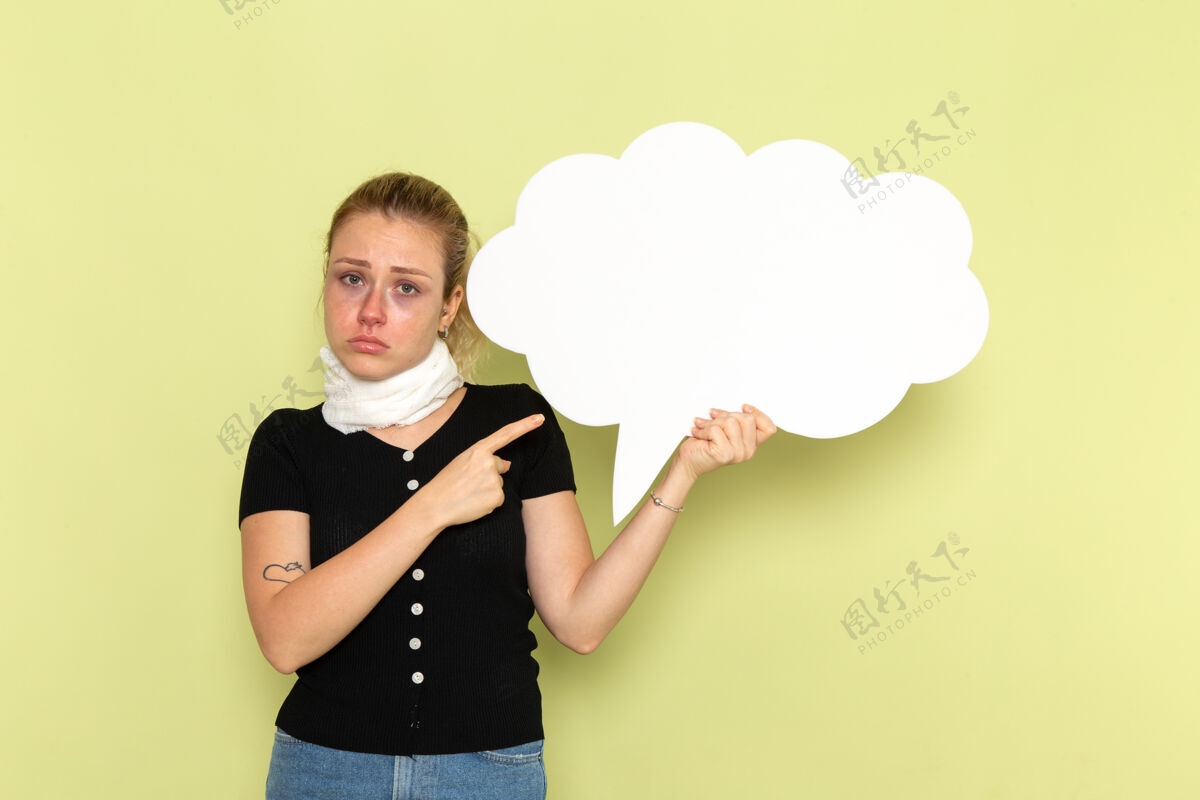 前面正面图年轻女子手握绿墙上巨大的白色标牌 感觉病得很厉害 病得很厉害颈部支架疾病观点