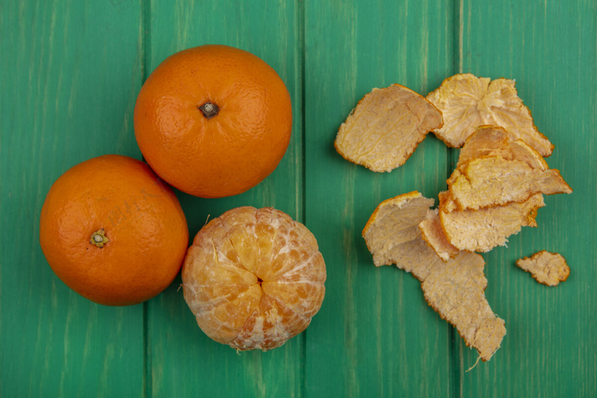 五颜六色绿色背景上带去皮橙子的俯视图橙色顶部景观
