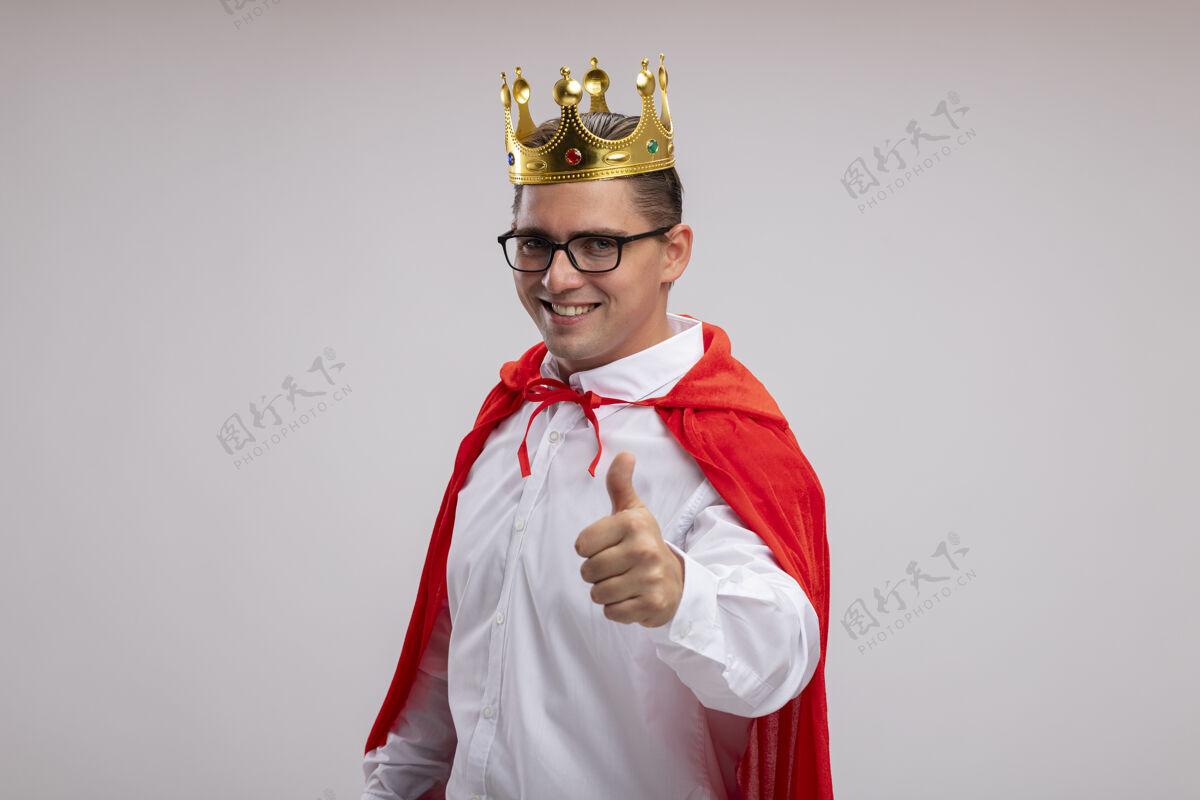 超级英雄身穿红色斗篷 戴着皇冠的超级英雄商人微笑着 站在白墙上竖起大拇指看站脸
