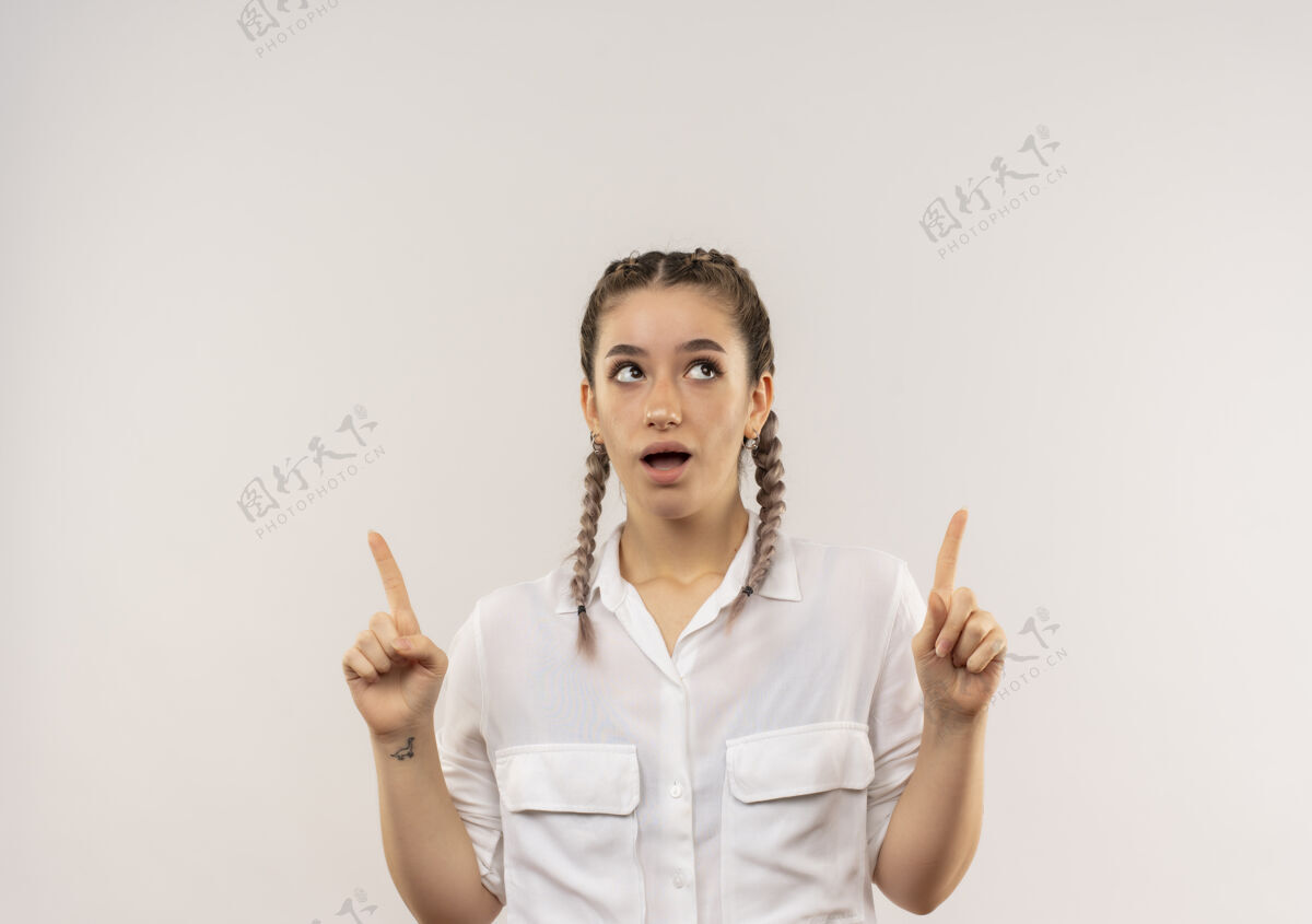 目录一个留着白衬衫辫子的年轻女学生站在白墙上 食指朝上 看起来很惊讶人站人