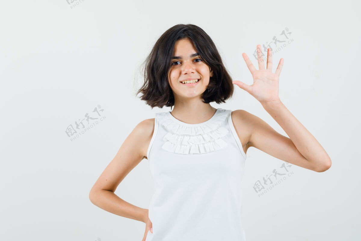 看穿着白衬衫的小女孩挥手致意或告别 看上去很快乐 正面照未成年休闲挥手
