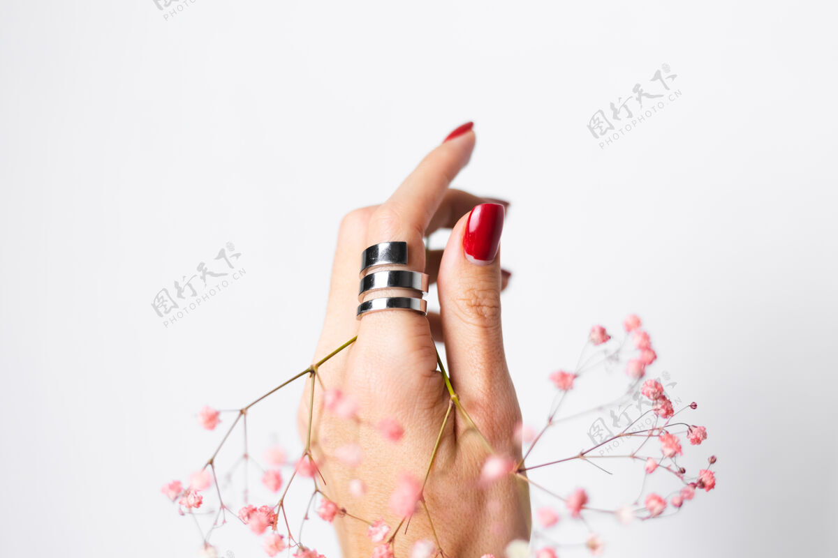 植物柔美温柔的照片 女人手上戴着大戒指 红色的指甲 手上拿着可爱的粉色干花浪漫叶花