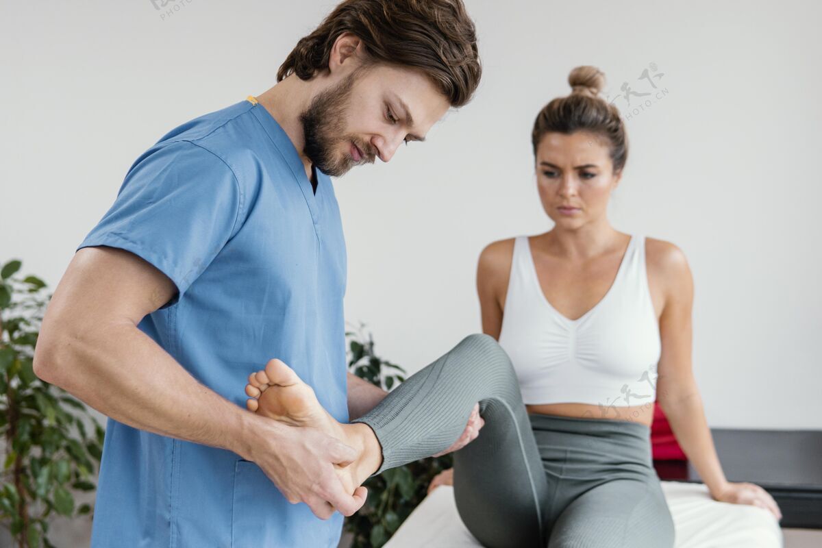 医生男性骨科治疗师正在检查女性患者的腿部运动男人运动水平
