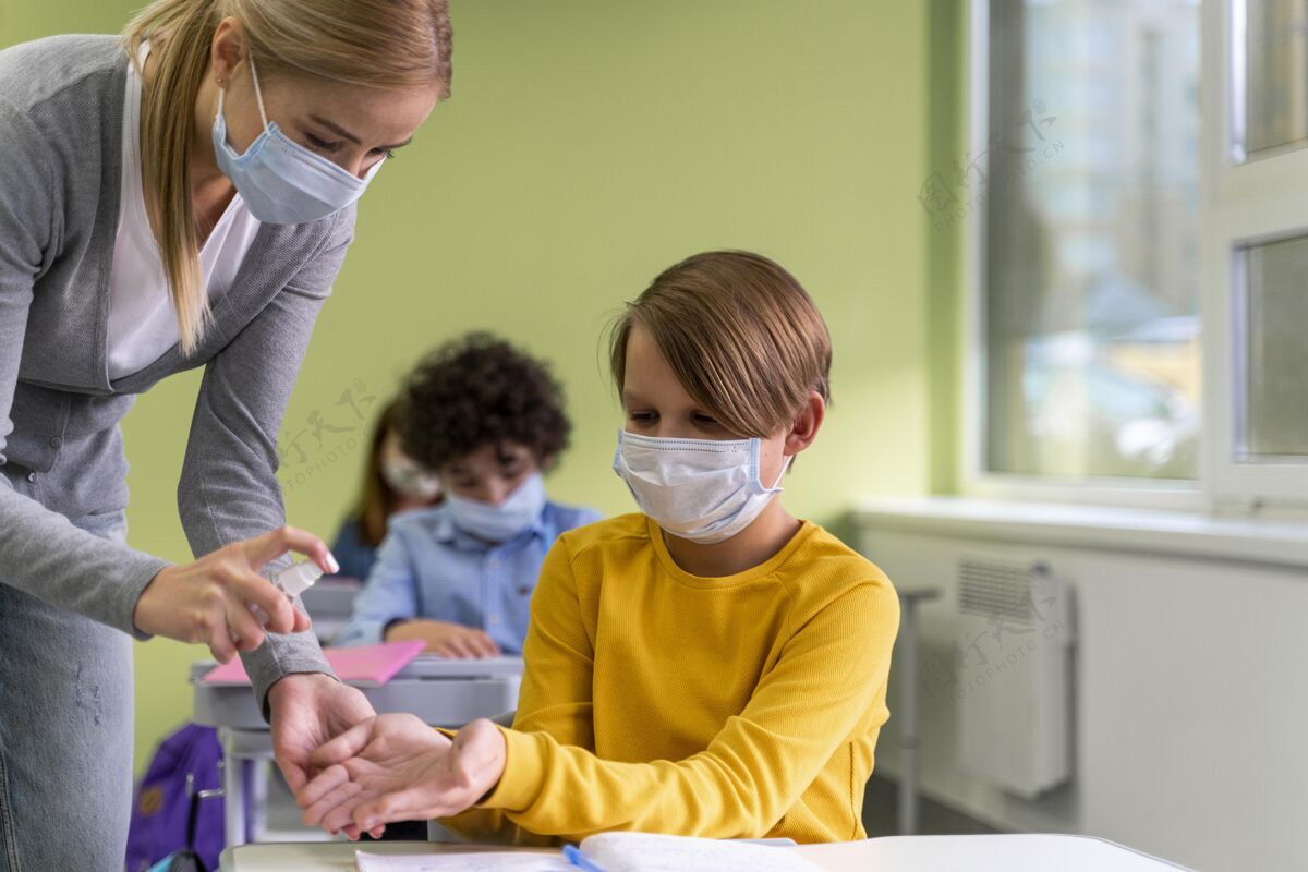 女性带着医用口罩的女老师在课堂上给孩子们洗手面罩课堂水平