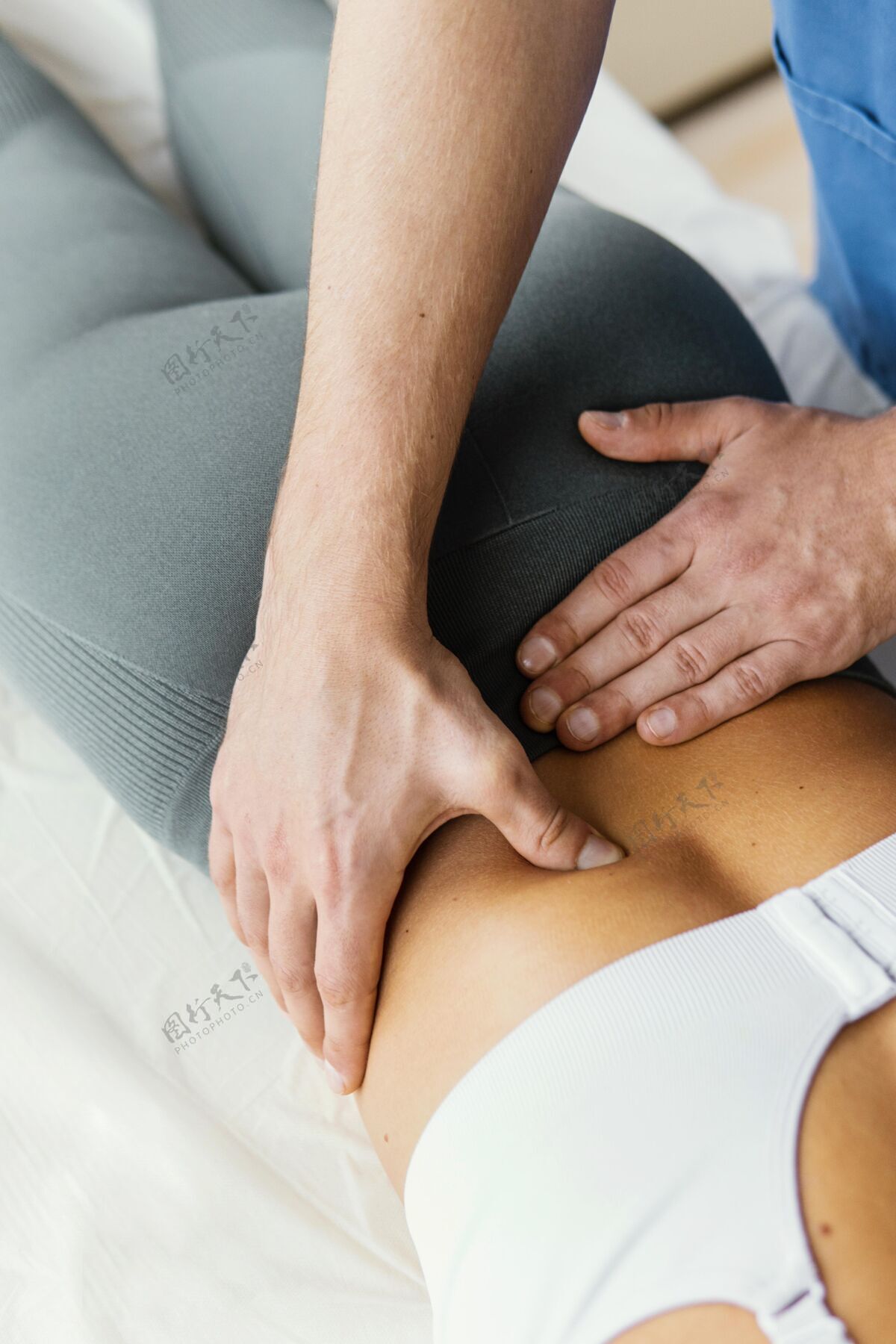 运动高角度男性骨科治疗师检查女性患者的下背部脊柱骨病治疗病人