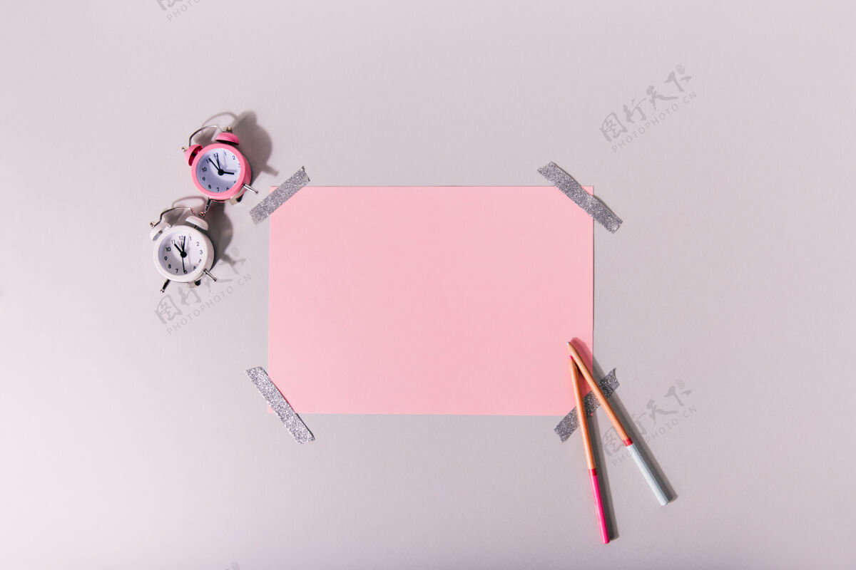 设备迷你闹钟旁边有一套粉红色的文具办公室文具顶部