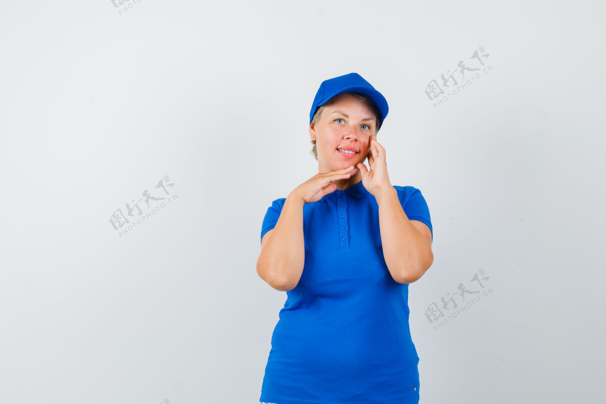 成熟穿着蓝色t恤的成熟女人一边抚摸脸部皮肤一边摆姿势触摸活跃女性