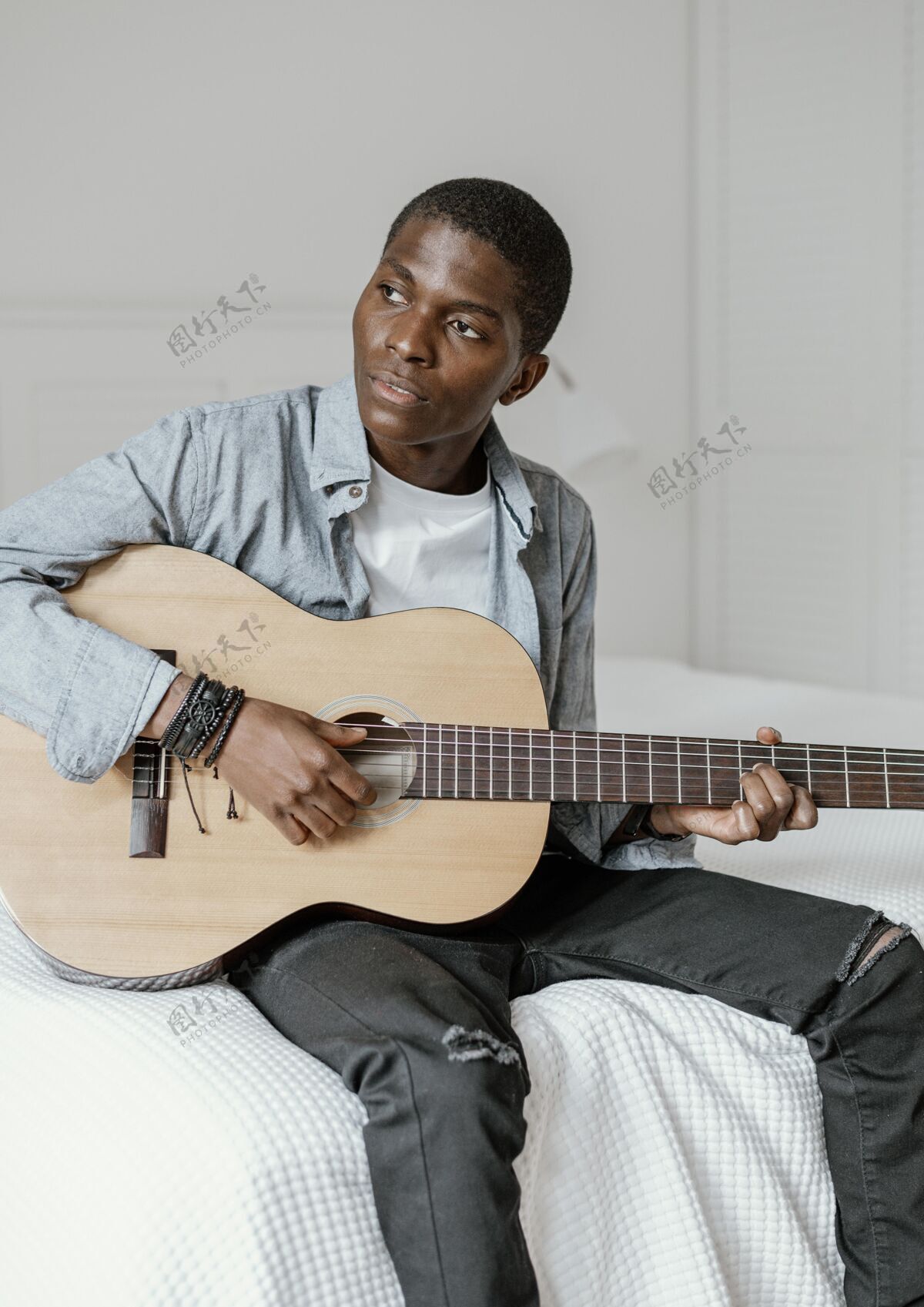 表演床上放着吉他的男音乐家的正视图垂直技能房子