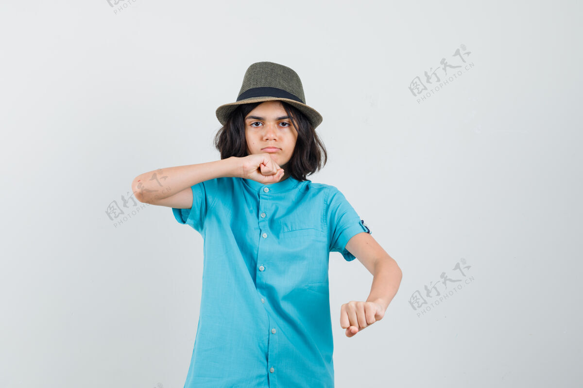 时尚一个穿着蓝色衬衫的少女举起拳头 看起来很严肃青少年提高严肃