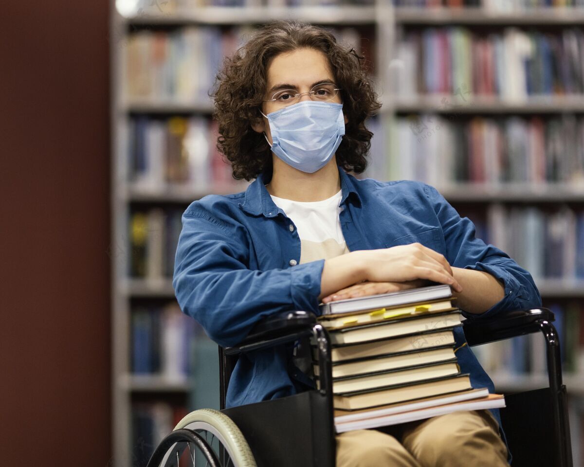 大学坐在轮椅上拿着一堆书的男孩大学知识面罩