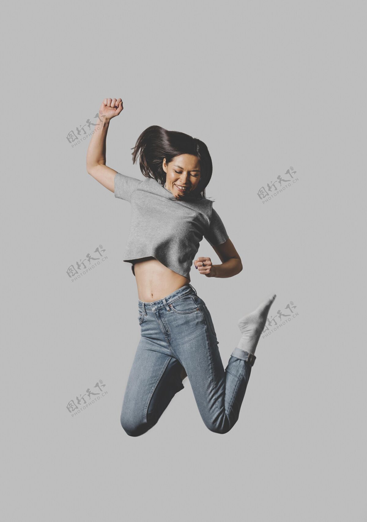 跳跃快乐女人在空中跳跃的正面视图人快乐女性