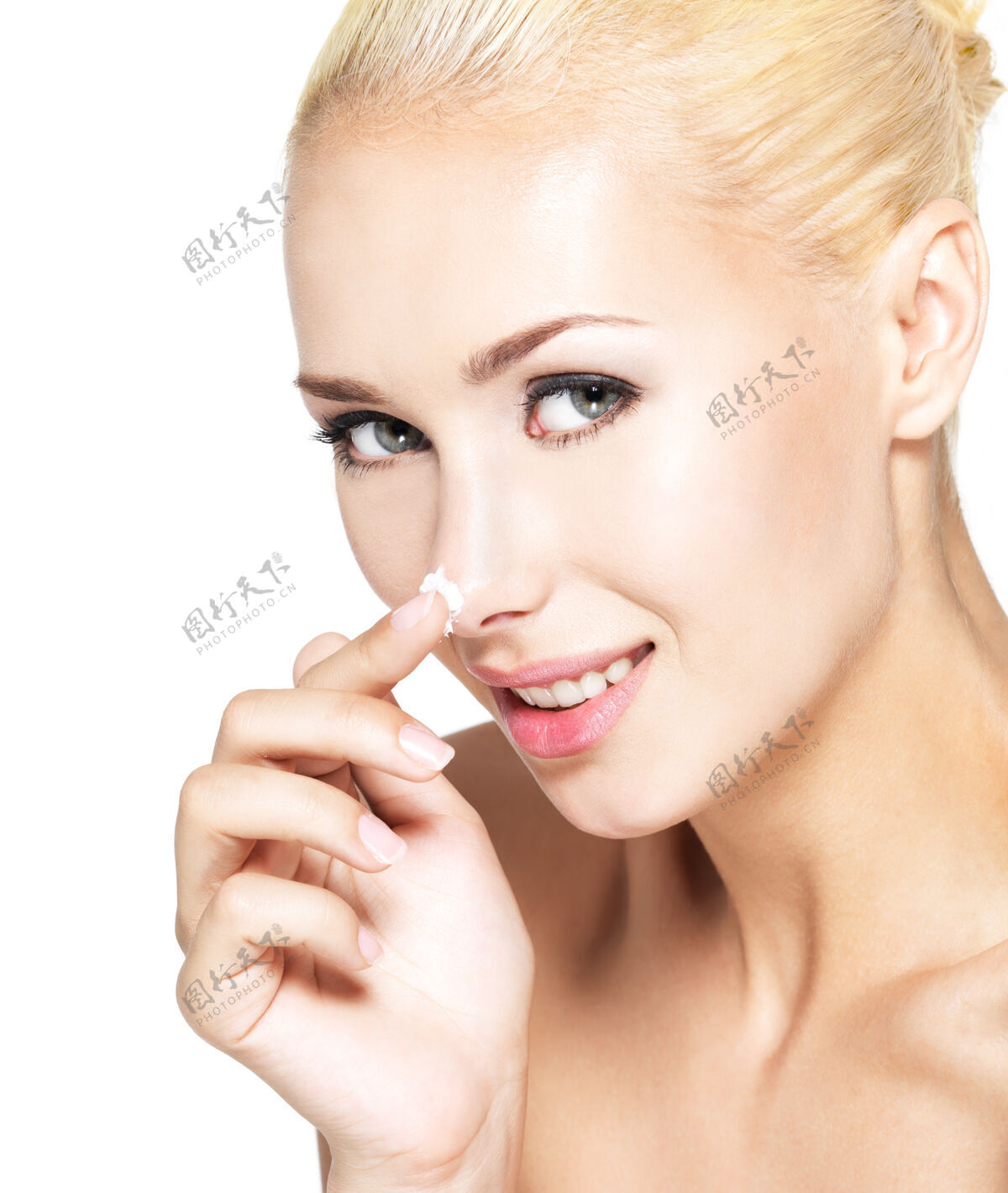 皮肤护理年轻女人在鼻子上涂化妆霜-孤立宠爱金发女人